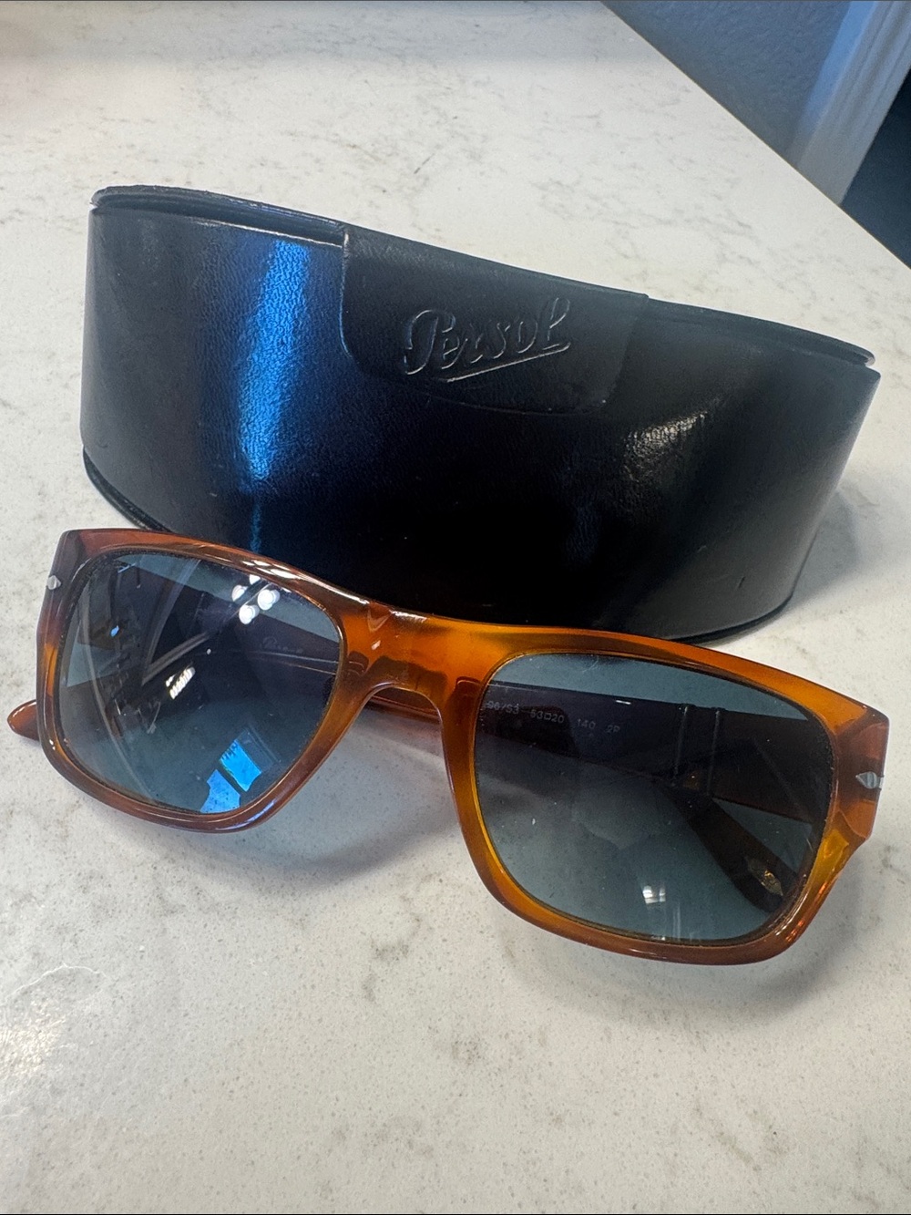 Persol Amber Tortoiseshell Frame Sunglasses with dark blue green lenses.